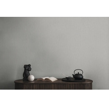 Behang op een muur met dressoir, sculptuur, boek en theeservies