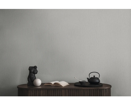 Behang op een muur met dressoir, sculptuur, boek en theeservies