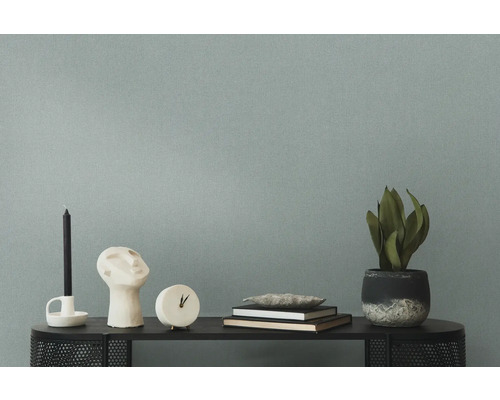 Decoratieve objecten zoals kaars, sculptuur, klok, boeken en potplant op een tafel