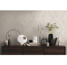 Wanddecoratie met beige behang en klassiek patroon op een dressoir met decoratieve vazen en boeken