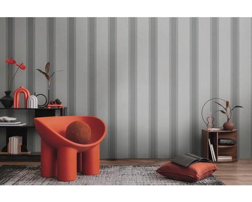 Decoratief interieur met gestreept behang, fauteuil en woonaccessoires