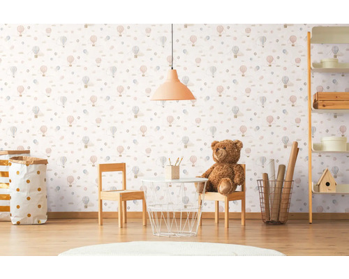 Kinderkamer met behang met luchtballonmotief, tafel, stoelen en speelgoed