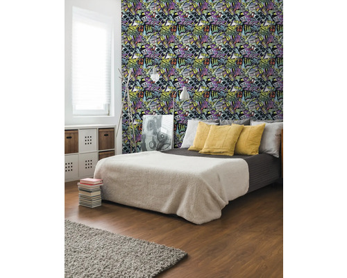 Slaapkamer met bed en behang met graffitimotieven