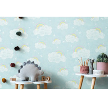 Kinderkamer met wolkenregenboogbehang, dinosaurusknuffel en decoratie op een tafel