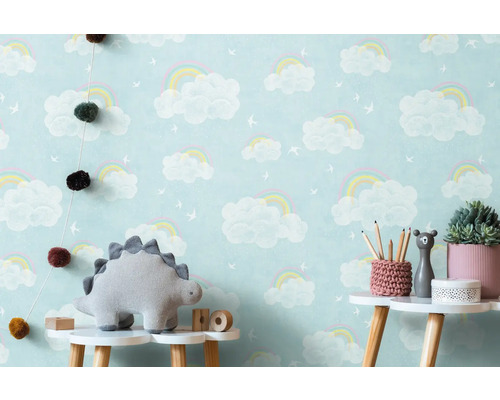 Kinderkamer met wolkenregenboogbehang, dinosaurusknuffel en decoratie op een tafel