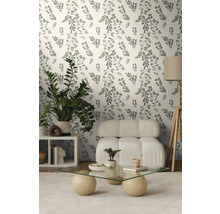 Woonkamer met bloemenbehang, fauteuil, tafel en kamerplanten.