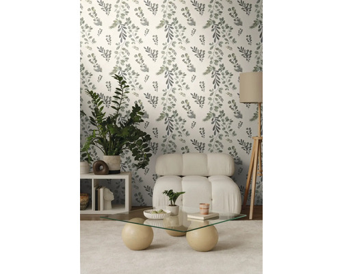 Woonkamer met bloemenbehang, fauteuil, tafel en kamerplanten.