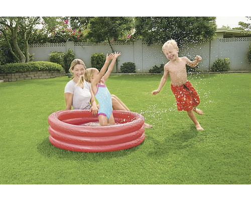Familie met opblaasbaar kinderzwembad in de tuin