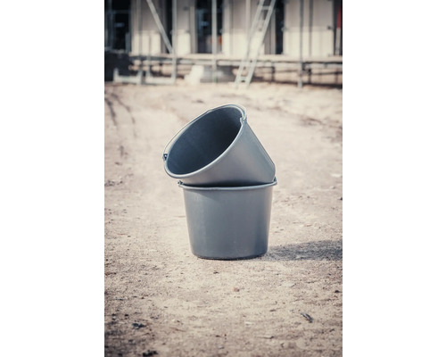 Twee kunststof speciekuipen staan op een bouwplaats op elkaar gestapeld.