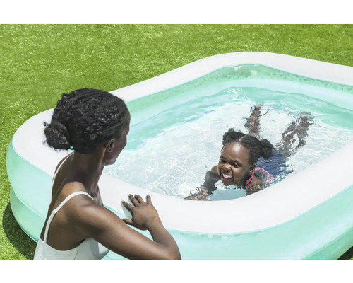 Moeder en kind in opblaasbaar zwembad in de tuin