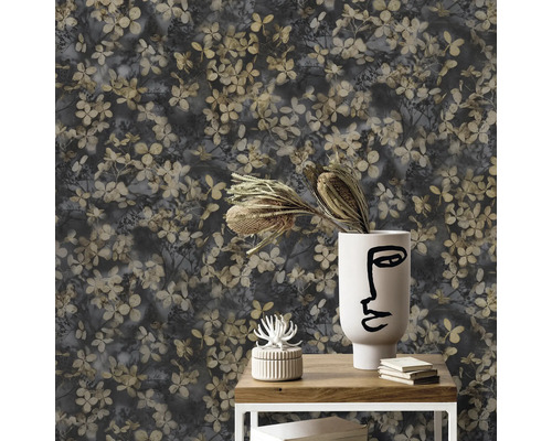 Close-up van een muur met een bloemenbehangpatroon, dat is gerangschikt op een klein tafeltje met decoratie.