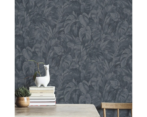 Wand met donker behang met bladeren, versierd met planten en boeken.