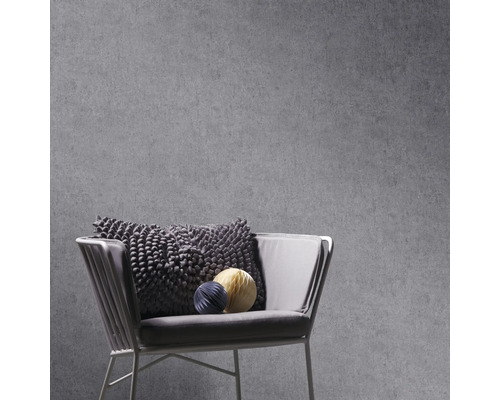 Grijs betonlook behang met fauteuil en decoratieve kussens