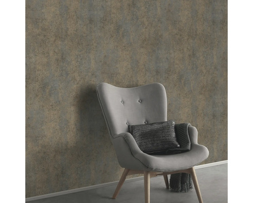 Wanddecoratie met grijs vliesbehang naast een fauteuil.