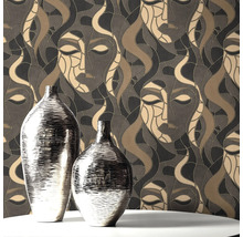 Twee zilverkleurige vazen op een tafel voor een behang met gezichtsmotief.