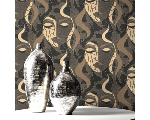 Twee zilverkleurige vazen op een tafel voor een behang met gezichtsmotief.