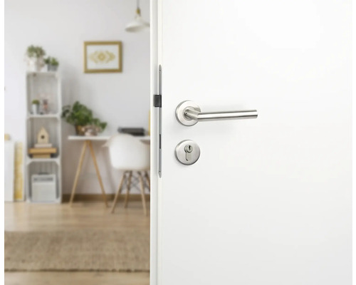 Open witte deur met zilverkleurige deurklink voor een lichte kamer