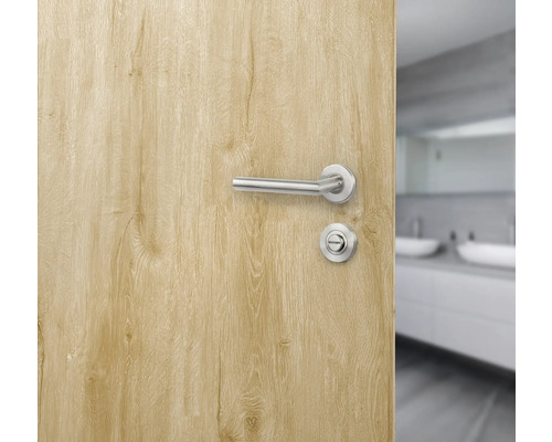 Open deur met deurkrukset en badkamer op de achtergrond