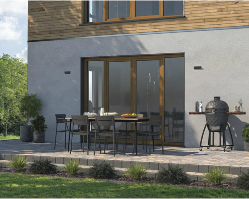 Terras met tuintafel, stoelen en keramische barbecue bij het woonhuis