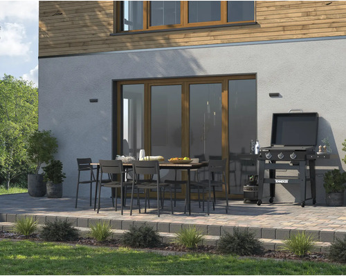 Terras met barbecue, tuintafel en tuinstoelen voor een huisgevel