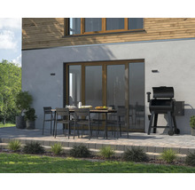 Buitenruimte met eettafel, stoelen en barbecue naast het huis