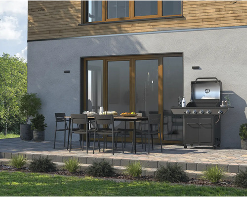 Terras met tuingrill, eettafel en stoelen voor een huis