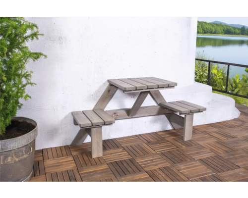 Tuinscene met houten tafel en banken voor een witte muur