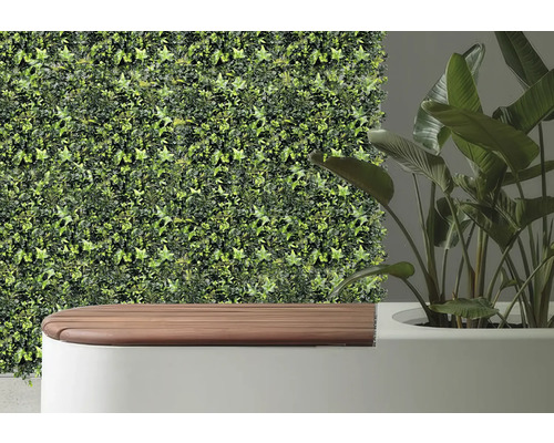 Decoratieve wandbekleding met kunstmatige klimop naast een bank en een kamerplant.