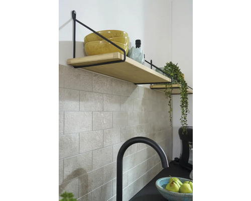 Planken met houten planken en zwarte beugel aan een betegelde muur in de keuken.