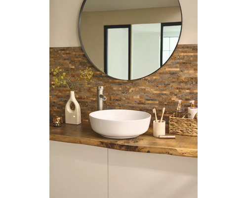 Badkamer met ronde spiegel, opzetwastafel, kraan en decoratie op een houten blad