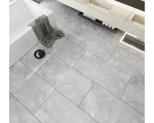 Badkamer met ligbad, wastafel en vloertegels met marmerlook