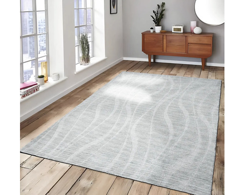 Grijs vloerkleed met golfpatroon in een woonkamer op een houten vloer