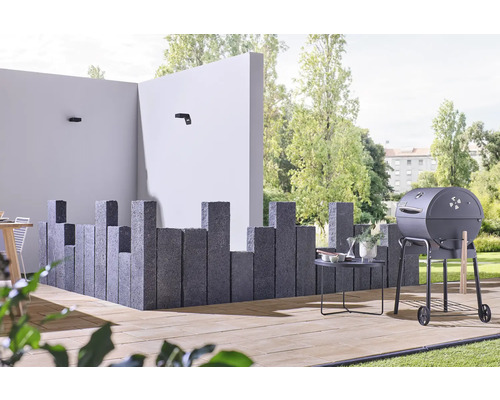 Buitenruimte met barbecue, stenen zuilen en tuinmeubelen op een terras
