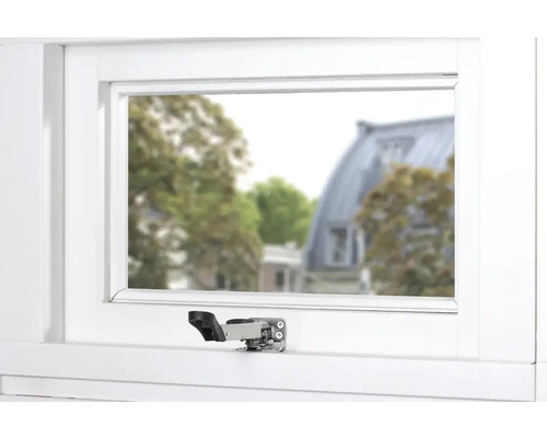 Gekanteld raam met raambeslag in een wit frame.