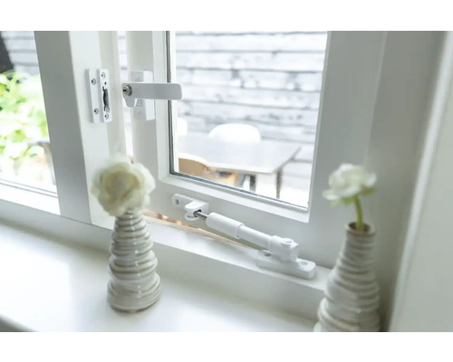 Raam met raamkruk, uitzetijzer en decoratie op de vensterbank