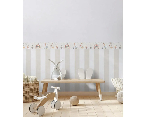 Kinderkamer met gestreept behang en circusmotief, met houten bank, speelgoed en decoratie
