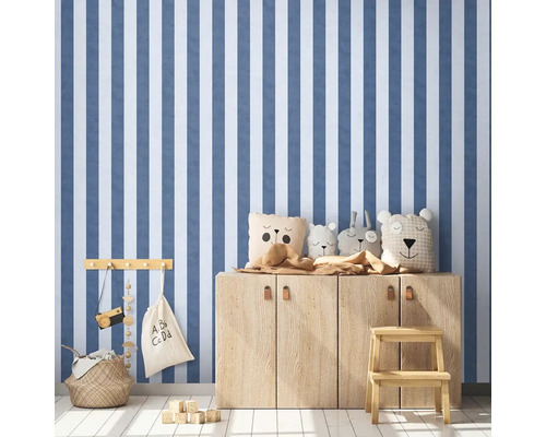 Kinderkamer met gestreept behang, houten dressoir en speelgoed.