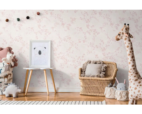 Kinderkamer met behang met bloemmotief, rotan meubels en knuffels.