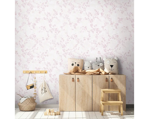 Kinderkamer met bloemenbehang, houten commode en speelgoeddecoratie.