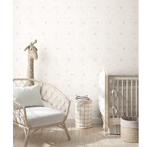 Kinderkamer met stoel, kinderbed en opbergmanden tegen een muur met stippenpatroon.