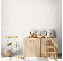 Kinderkamer met licht behangpatroon, houten kast en decoraties.
