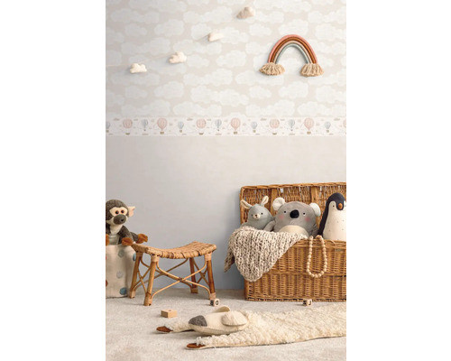 Kinderkamer met wolkenbehang, speelgoed en rieten mand