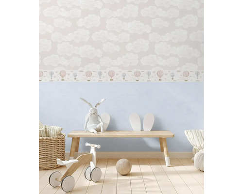 Kinderkamer met behang met wolken- en ballonmotief, houten bank, stoffen konijn en houten speelgoed