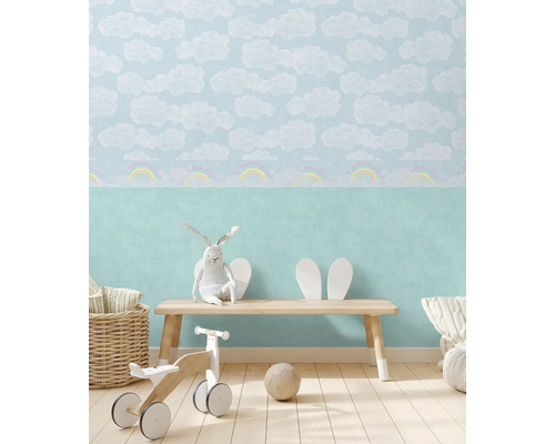 Kinderkamer met wolkenbehang, houten bank, speelgoed en accessoires