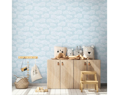 Kinderkamer met wolkenbehang, houten dressoir en speelgoed
