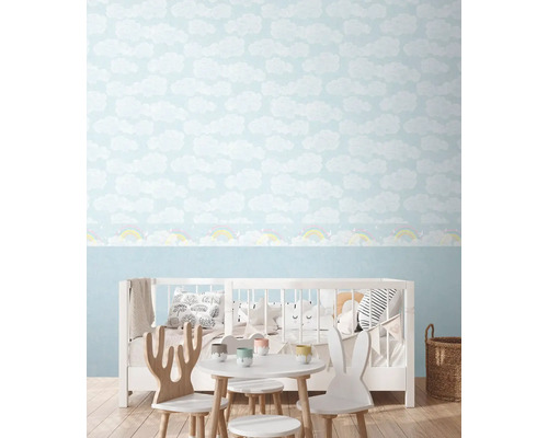 Kinderkamer met wolkenbehang en kindermeubels.