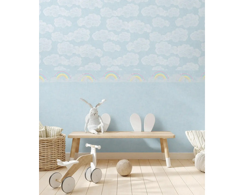 Kinderkamer met wolken- en regenboogbehang, houten bankje en speelgoed