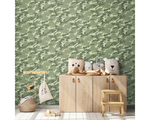 Gedecoreerde kinderkamer met camouflage behang, houten kast, decoratieve kussens, opbergmand en speelgoed