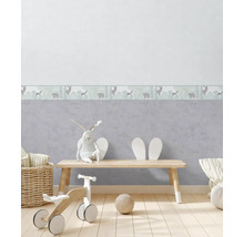 Kinderkamer met behangrand met dierillustraties, houten vloer en speelgoed.