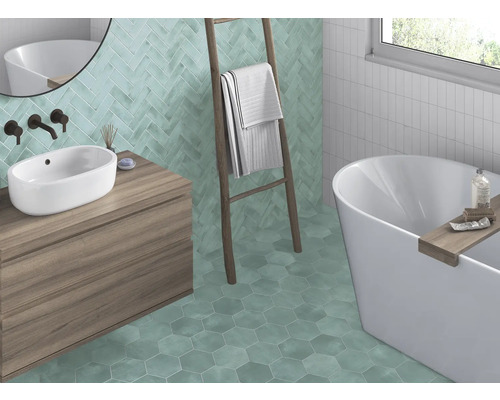 Badkamer met wastafel, bad, ladder en wand- en vloertegels in verschillende vormen